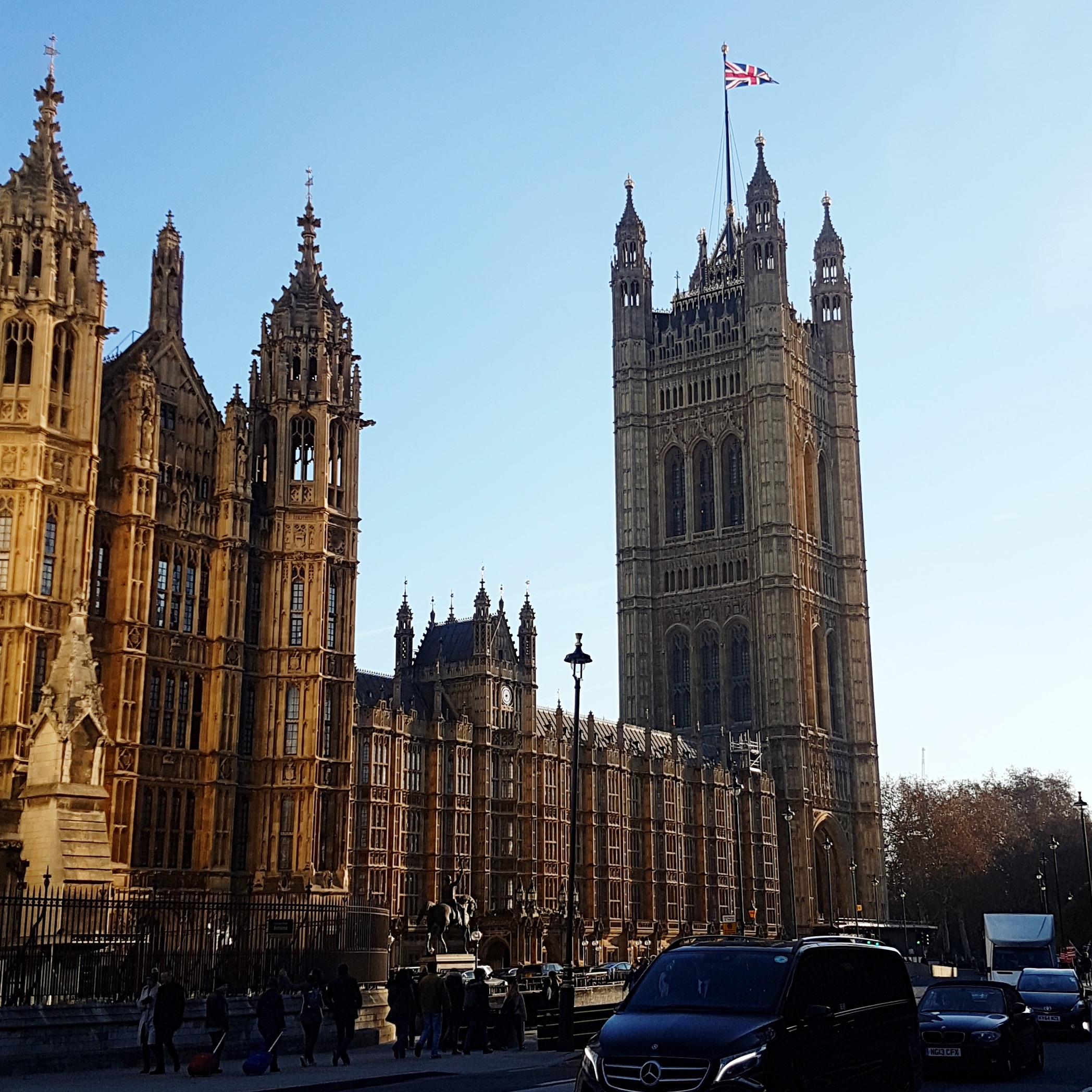 Highly ornate neo gothic building (the UK Houses of Parliament) pictured from across a road.